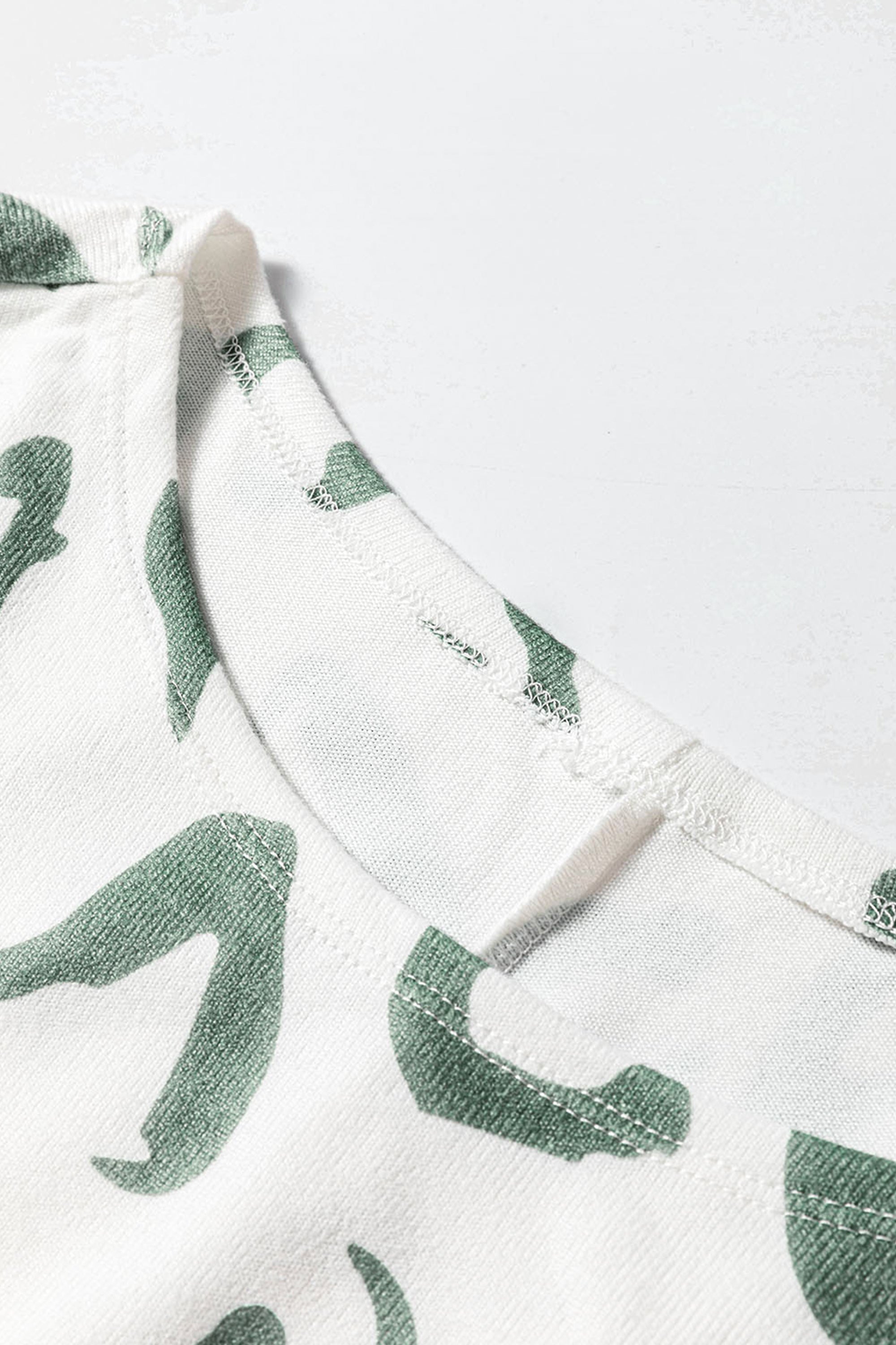 طقم نسائي مريح لون بيج وأخضر مع طبعة جلد النمر مكون من بلوزة كم طويل وبنطلون مريح.