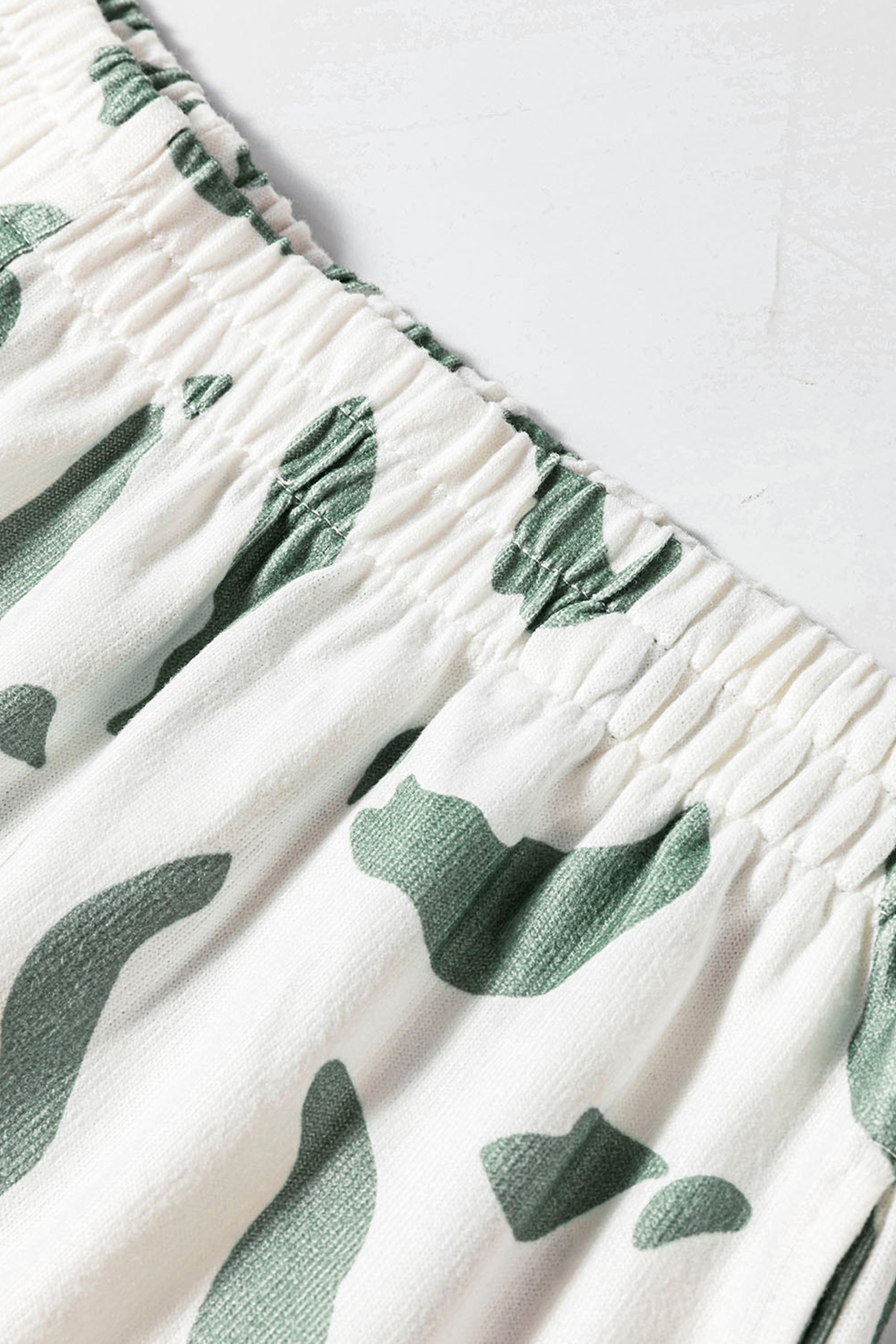 طقم نسائي مريح لون بيج وأخضر مع طبعة جلد النمر مكون من بلوزة كم طويل وبنطلون مريح.