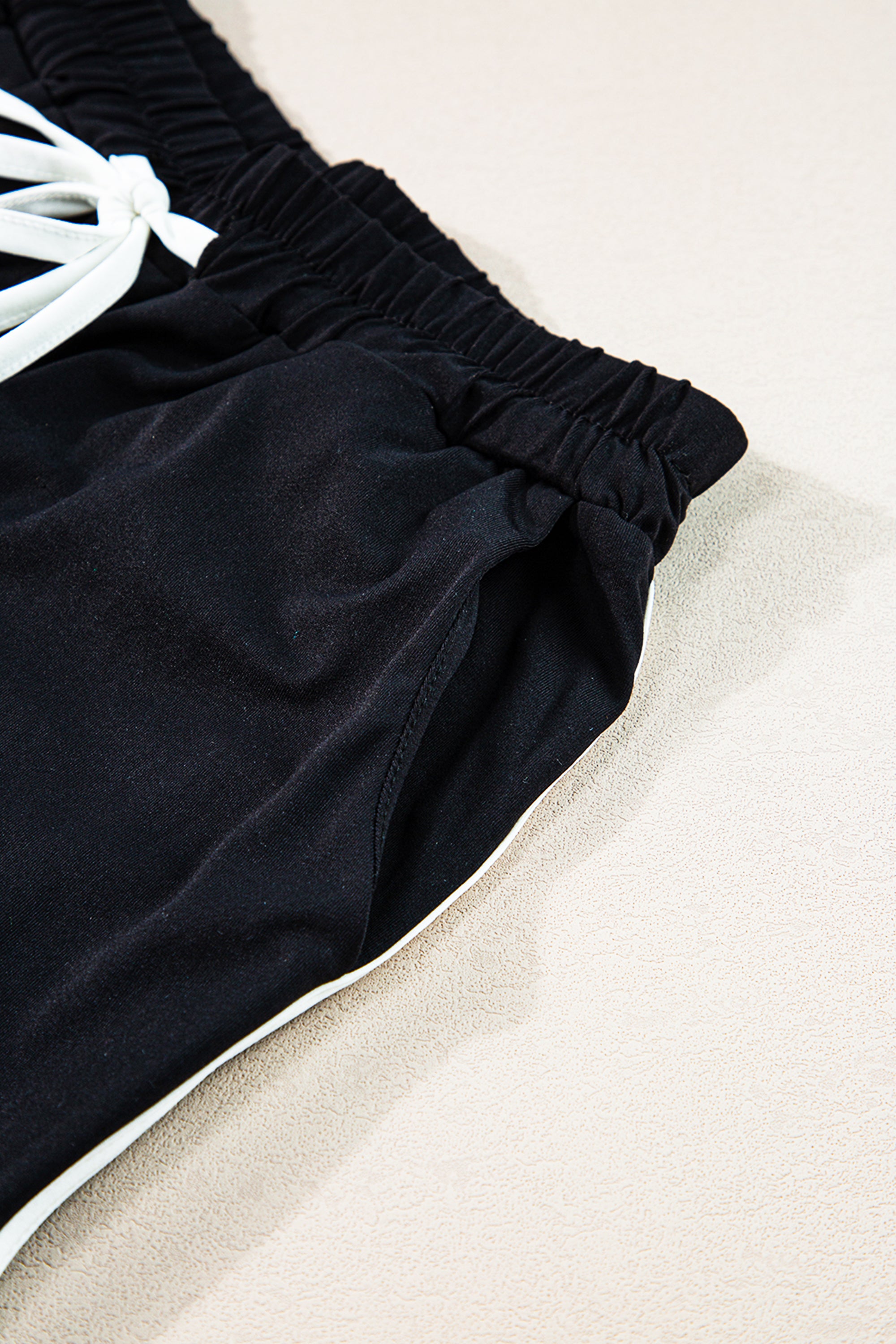 طقم مميز لإطلالة رياضية مذهلة مكون من تيشيرت كاجوال وبنطلون مع حبل لتعديل مقاس الخصر. اللون، أسود مع خطوط جانبية بيضاء.