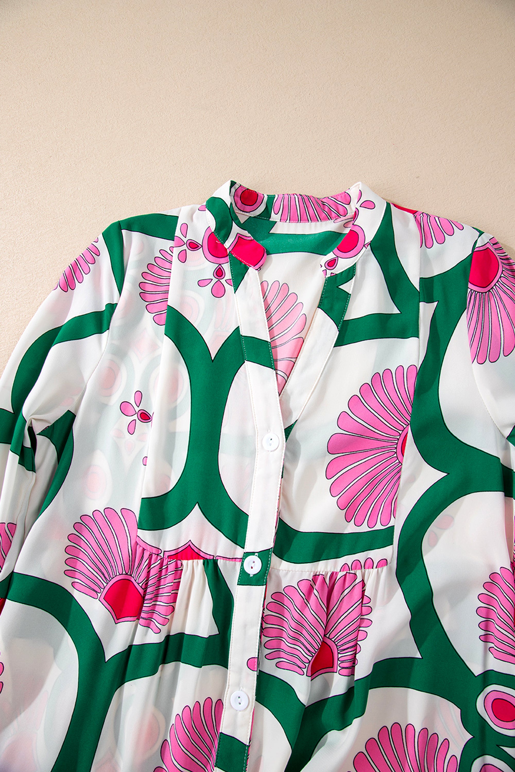 فستان أنيق ومفعم بالحيوية لون وردي مزود بأزرار ونقشة زهور وصميم بوحي بوهيمي. القصة الفضفاضة توفر راحة وأناقة، بينما الأكمام الطويلة تضفي لمسة عصرية ومتعددة الاستخدامات.