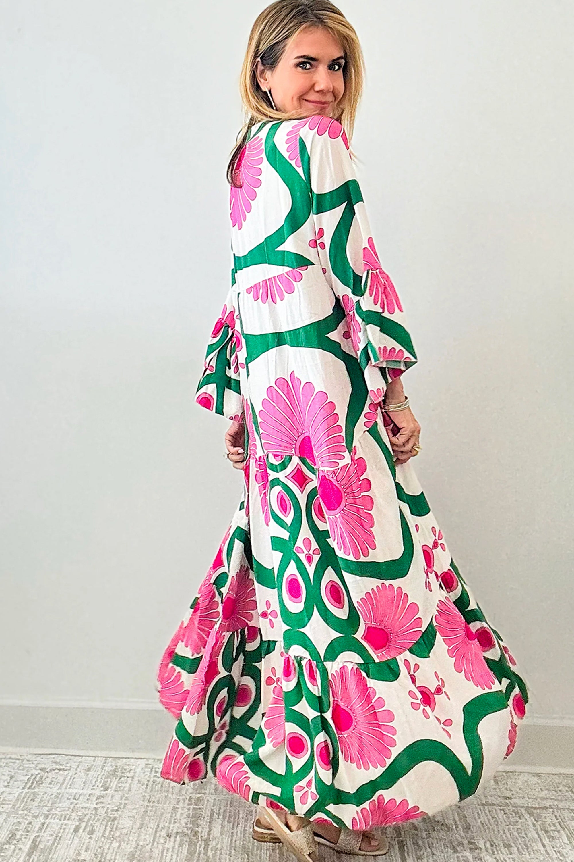 فستان أنيق ومفعم بالحيوية لون وردي مزود بأزرار ونقشة زهور وصميم بوحي بوهيمي. القصة الفضفاضة توفر راحة وأناقة، بينما الأكمام الطويلة تضفي لمسة عصرية ومتعددة الاستخدامات.