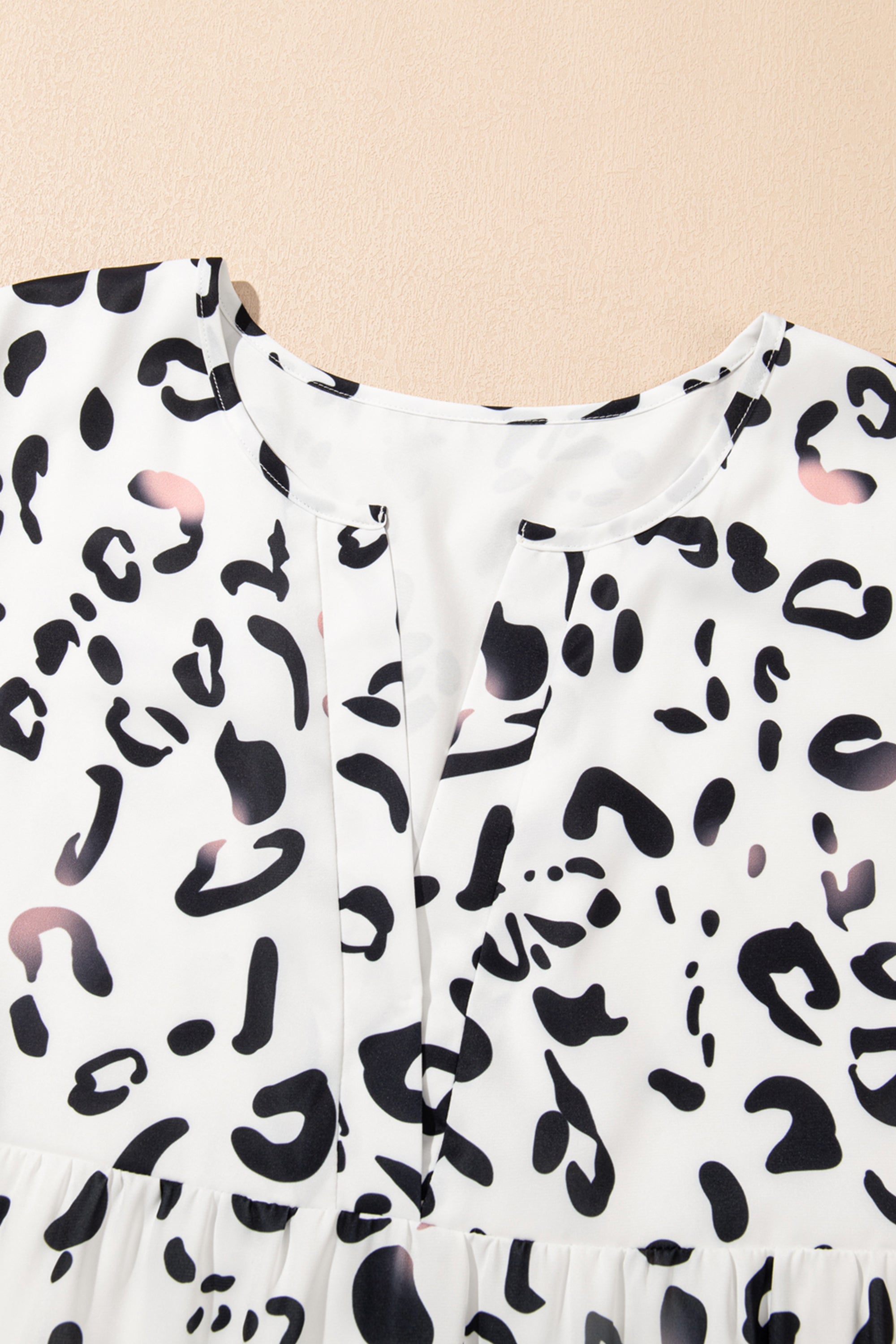 فستان طويل ابيض نقشة النمر. يتميز بتصميم أنيق وعصري، مع ياقة على شكل حرف V وأكمام مزمومة وقصة فضفاضة، بينما تضفي الطبقات على الطول الماكسي إطلالة مريحة وأكثر رشاقة وجاذبية.