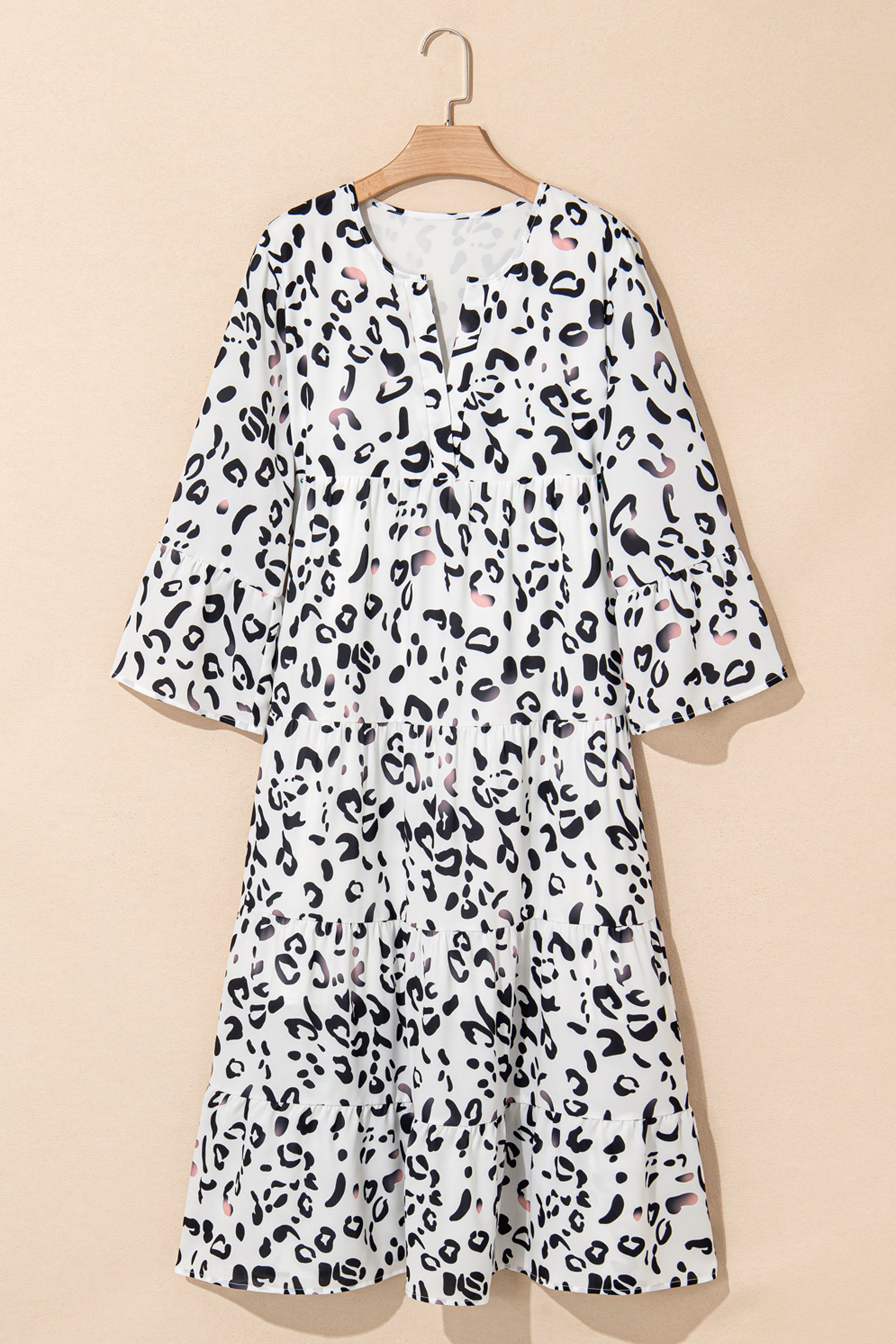 فستان طويل ابيض نقشة النمر. يتميز بتصميم أنيق وعصري، مع ياقة على شكل حرف V وأكمام مزمومة وقصة فضفاضة، بينما تضفي الطبقات على الطول الماكسي إطلالة مريحة وأكثر رشاقة وجاذبية.