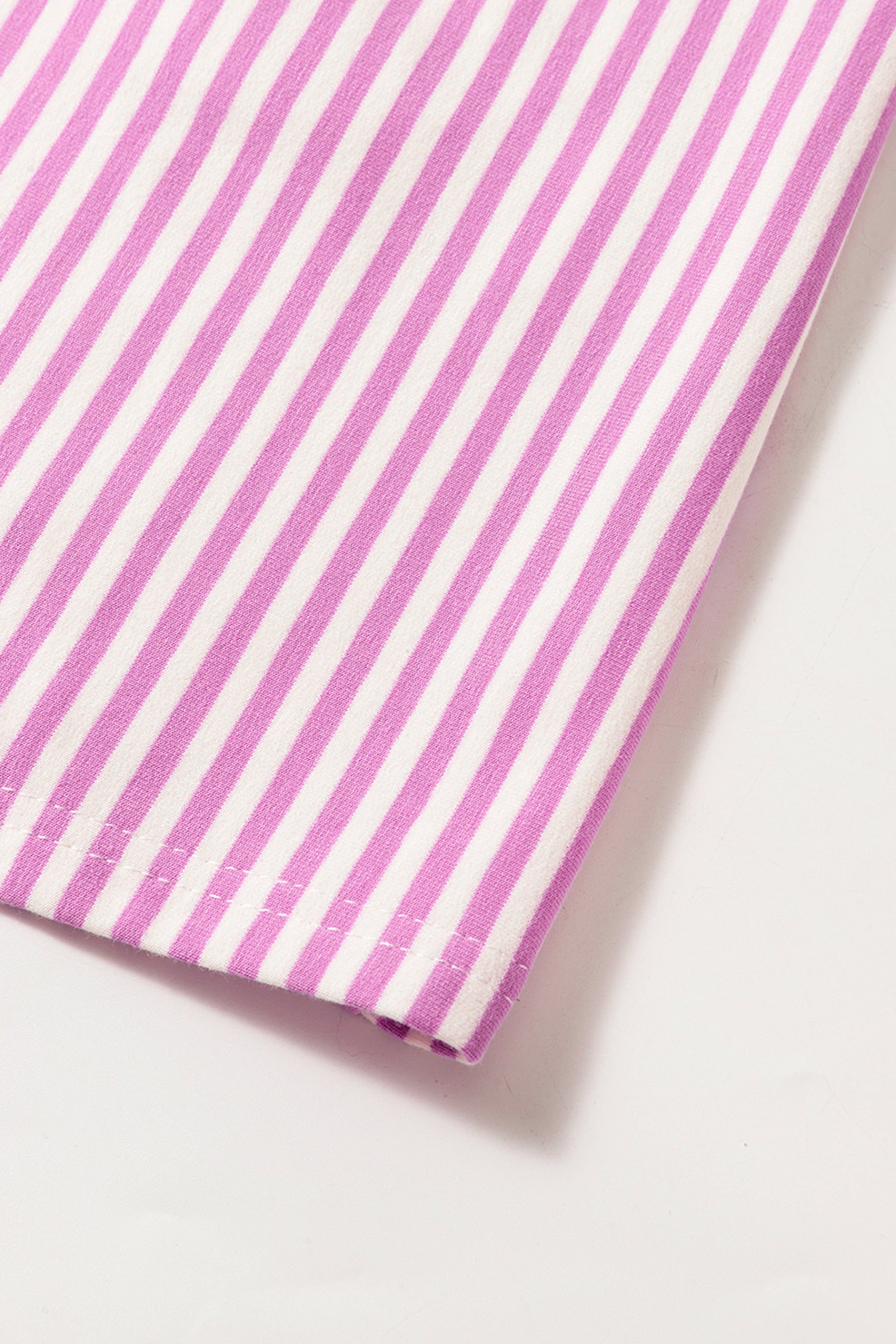 فستان تصميم واسع وجذاب يتميز بقماش مخطط باللونين الوردي والأبيض، ومصمم لإظهار تناسق الجسم. أكمام متوسطة الطول وياقة دائرية كلاسيكية.