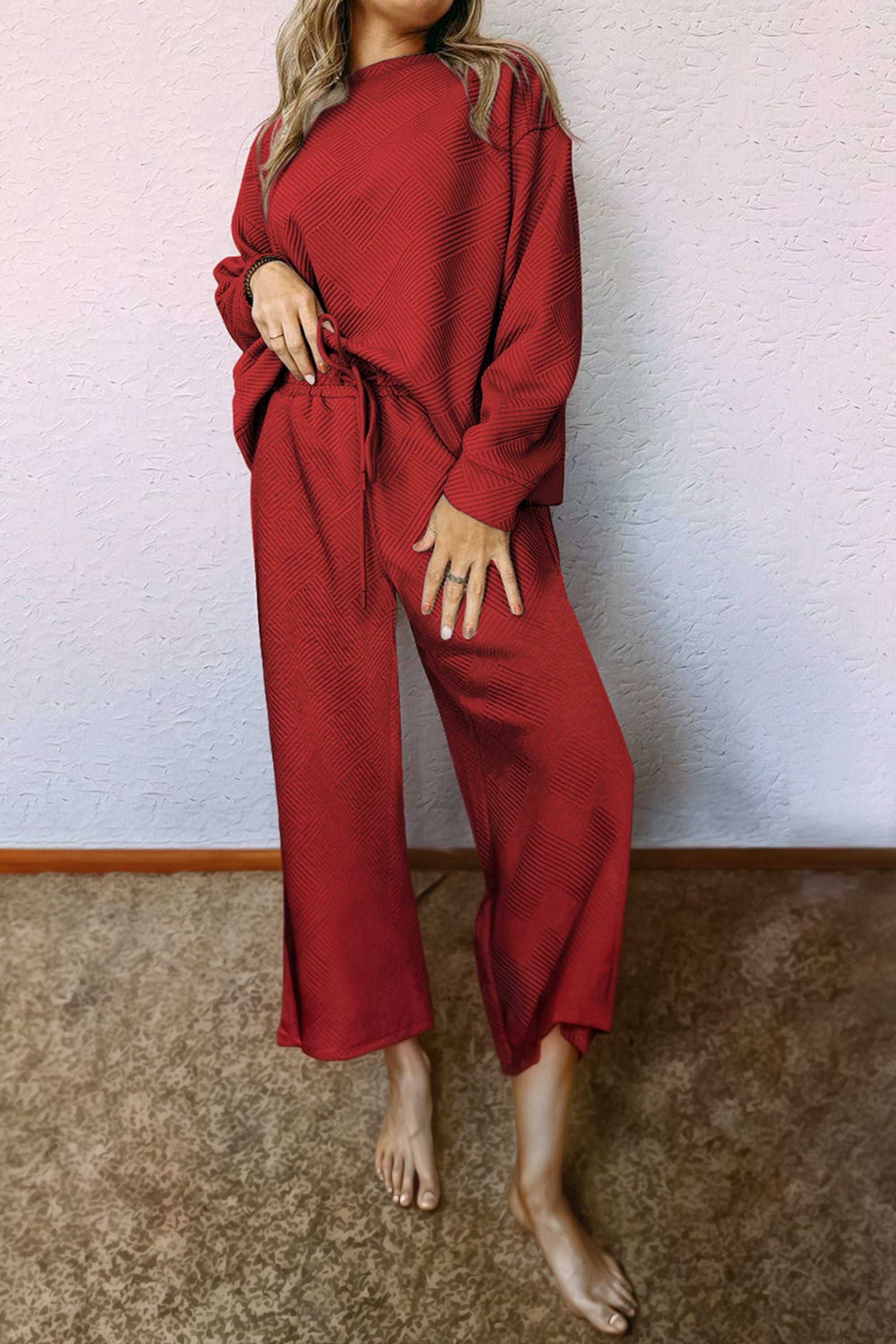 طقم نسائي مكون من بلوزة بأكمام طويلة وبنطلون قصة واسعة مزود بحبل على الخصر. مصنوع من قماش فخم وله نقشة نافرة لملمس ومظهر جذاب. مناسب لاستقبال الضيوف أو كملابس سفر.
خيارات الألوان: اسود، بني غامق، أحمر